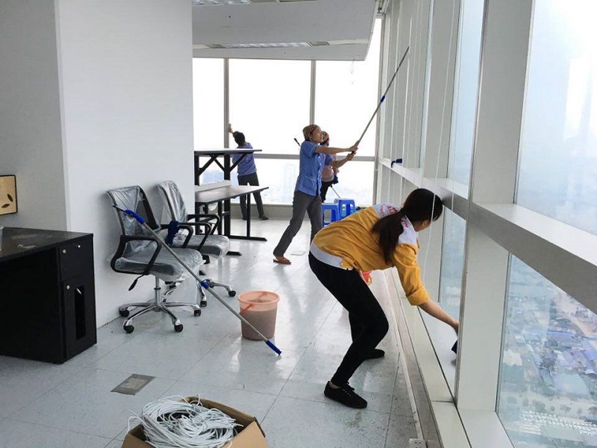 Nhân viên tiến hành lau các mặt kính, tường và sàn